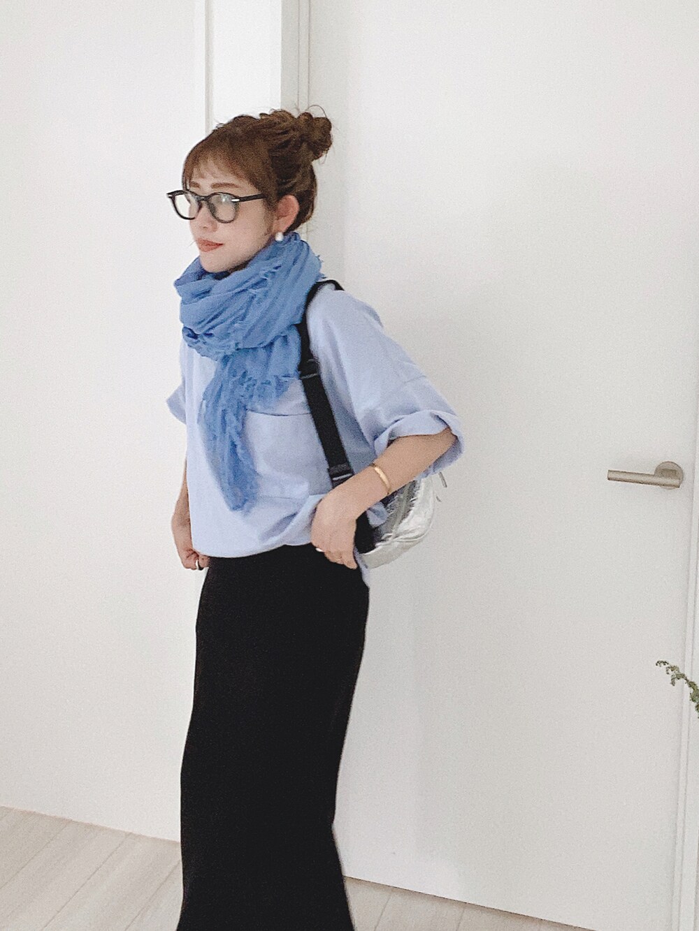 ブラック系のスカート、ブルー系のTシャツ/カットソー、ブラック系のサンダルを着用したレディースの夏コーディネートの2枚目の写真