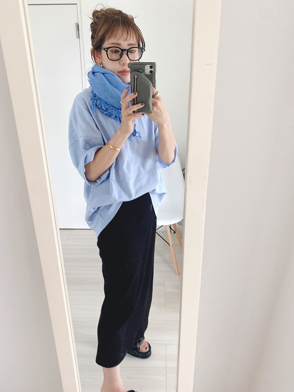 ブラック系のスカート、ブルー系のTシャツ/カットソー、ブラック系のサンダルを着用したレディースの夏コーディネートの3枚目の写真