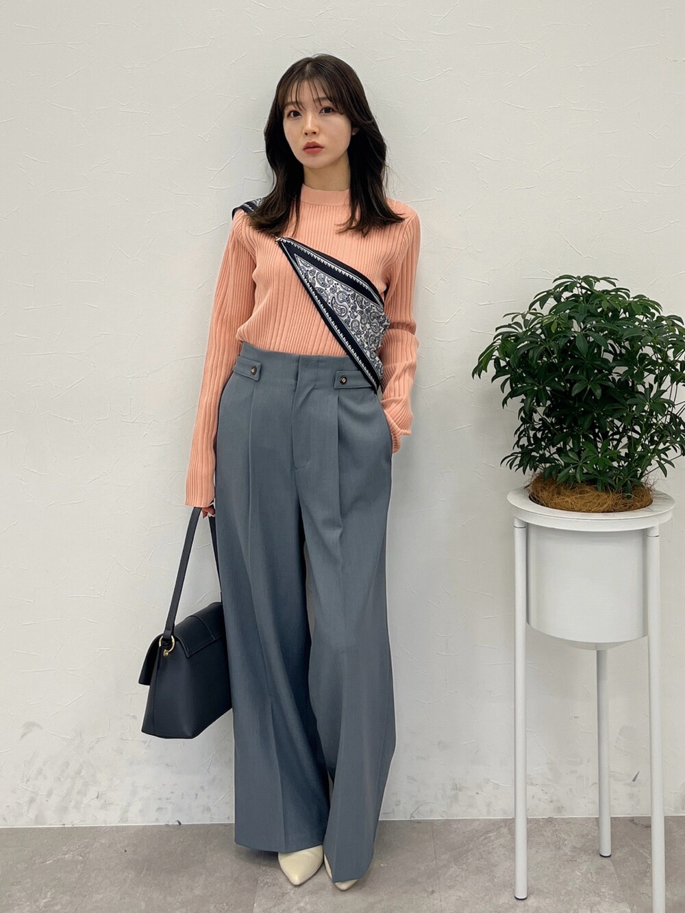 オレンジ系のテーラードジャケット、グレー系のハンドバッグ、グレー系のスラックスを着用したレディースの春コーディネートの4枚目の写真
