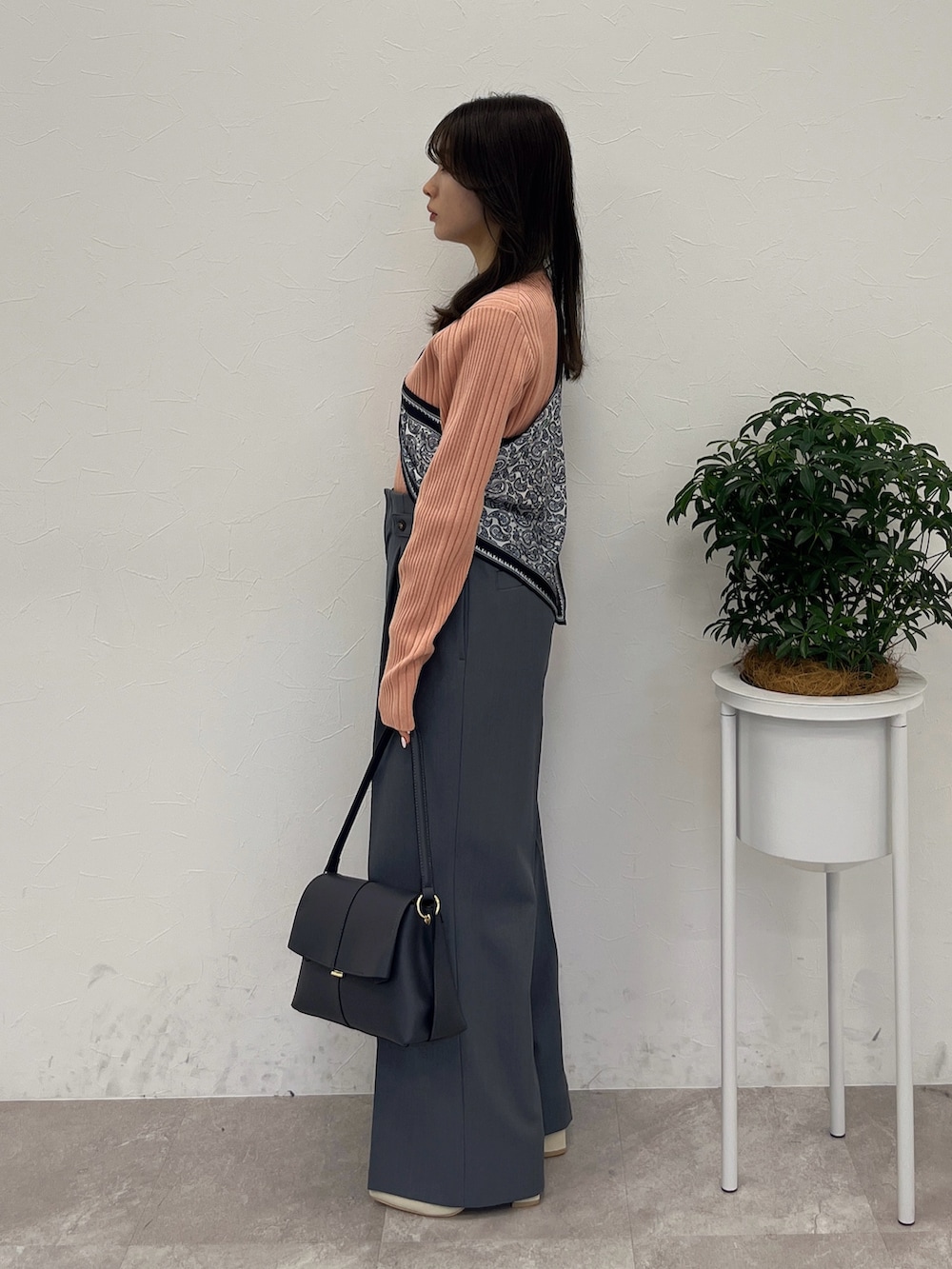 オレンジ系のテーラードジャケット、グレー系のハンドバッグ、グレー系のスラックスを着用したレディースの春コーディネートの5枚目の写真