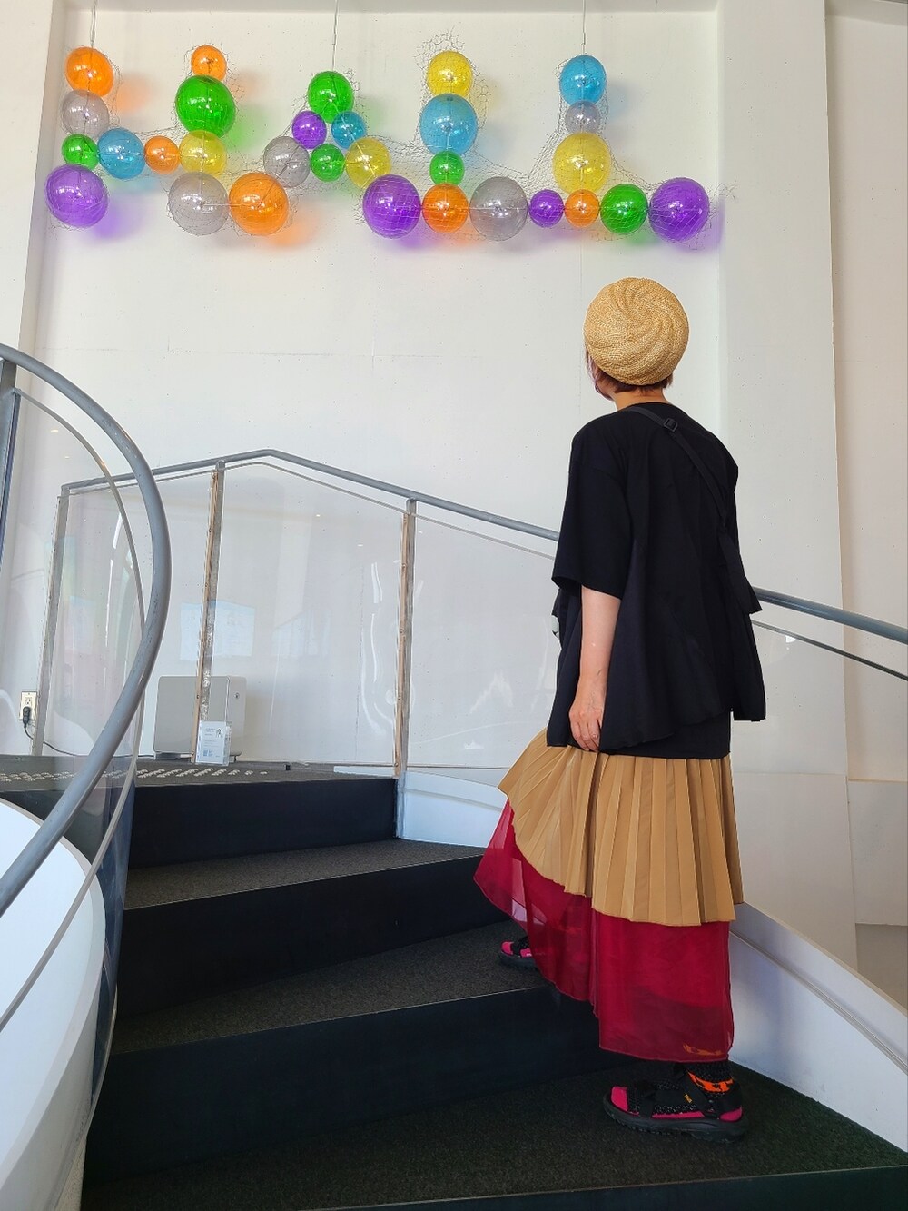 ブラック系のスカート、ブラック系のTシャツ/カットソー、ブラック系のショルダーバッグを着用したレディースの夏コーディネートの2枚目の写真