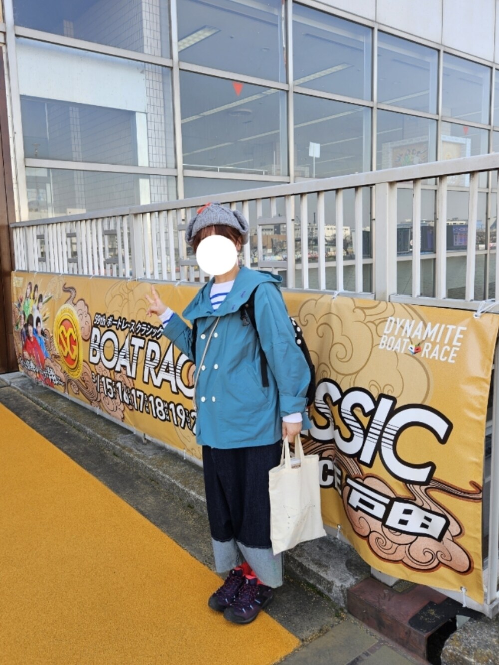 グリーン系のマウンテンパーカー、ブルー系のTシャツ/カットソー、ブルー系のデニムパンツを着用したレディースの春コーディネートの2枚目の写真