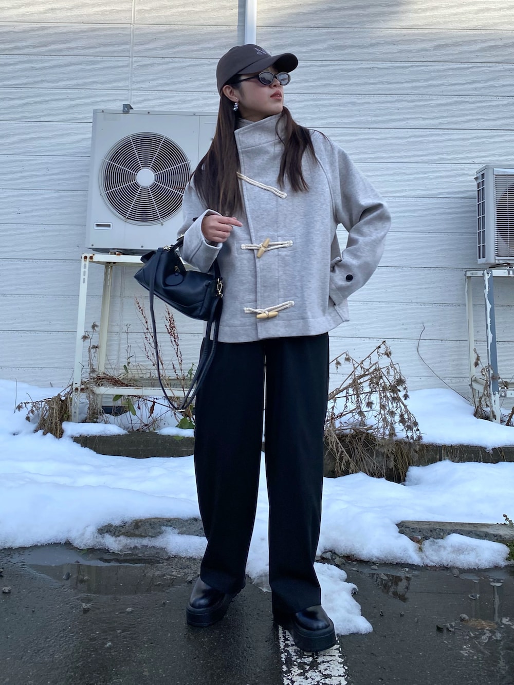 ブラック系のブーツ、ホワイト系のダッフルコート、ブラック系のハンドバッグを着用したレディースの秋コーディネートの4枚目の写真