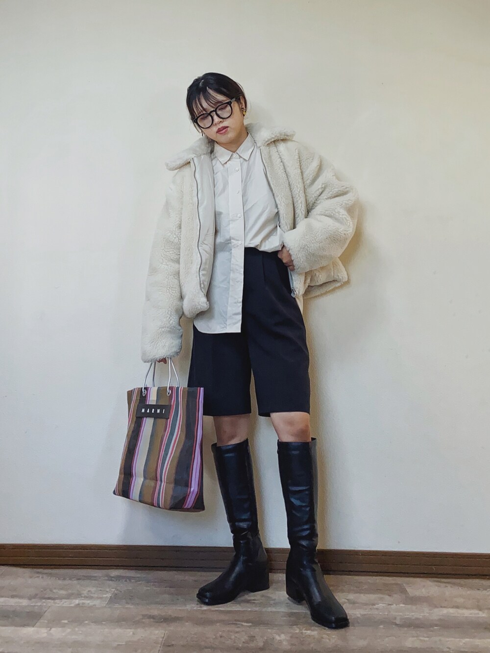 ホワイト系のその他アウター、ベージュ系のシャツ/ブラウス、ブラウン系のトートバッグを着用したレディースの秋コーディネートの2枚目の写真