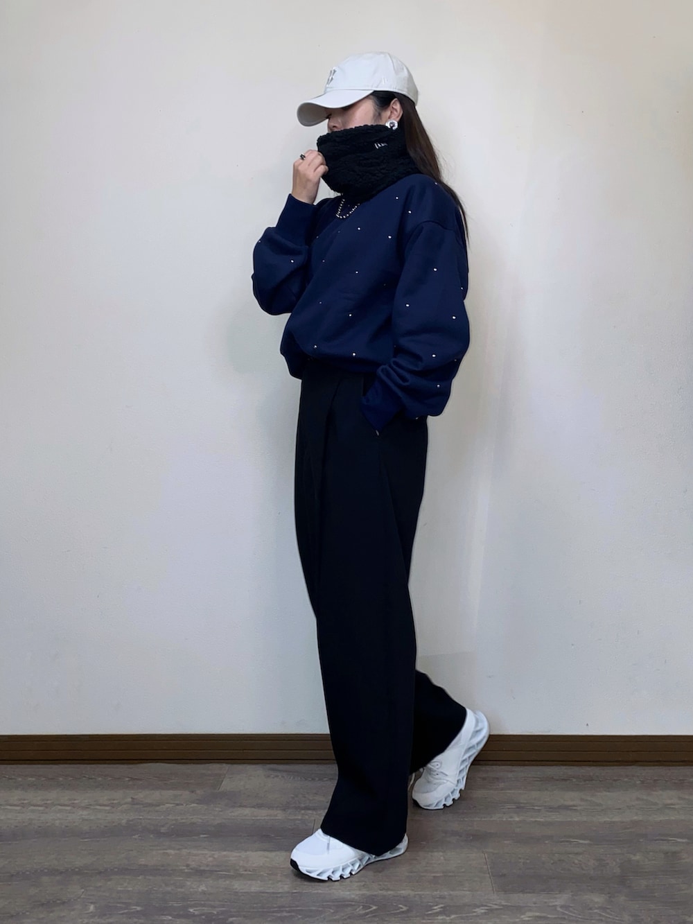 ブルー系のスウェット、ベージュ系のキャップ、ブラック系のネックウォーマー/スヌードを着用したレディースの冬コーディネートの3枚目の写真