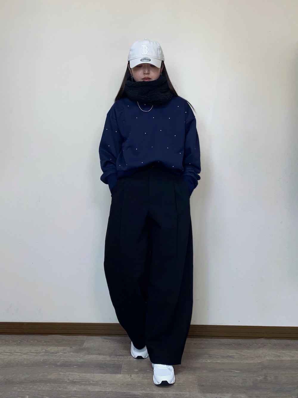 ブルー系のスウェット、ベージュ系のキャップ、ブラック系のネックウォーマー/スヌードを着用したレディースの冬コーディネートの5枚目の写真