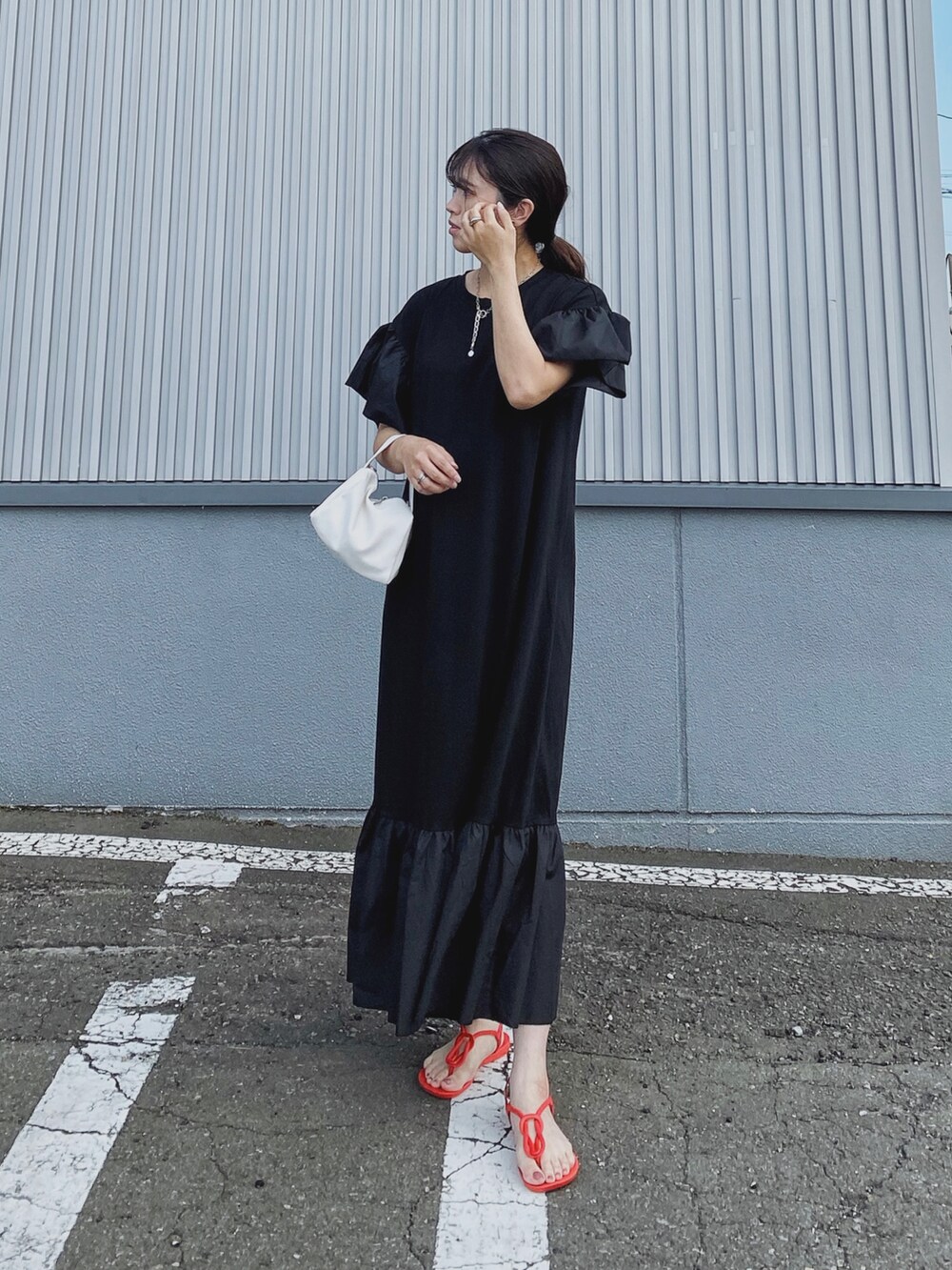 ブラック系のワンピース、レッド系のサンダルを着用したレディースの夏コーディネートの2枚目の写真