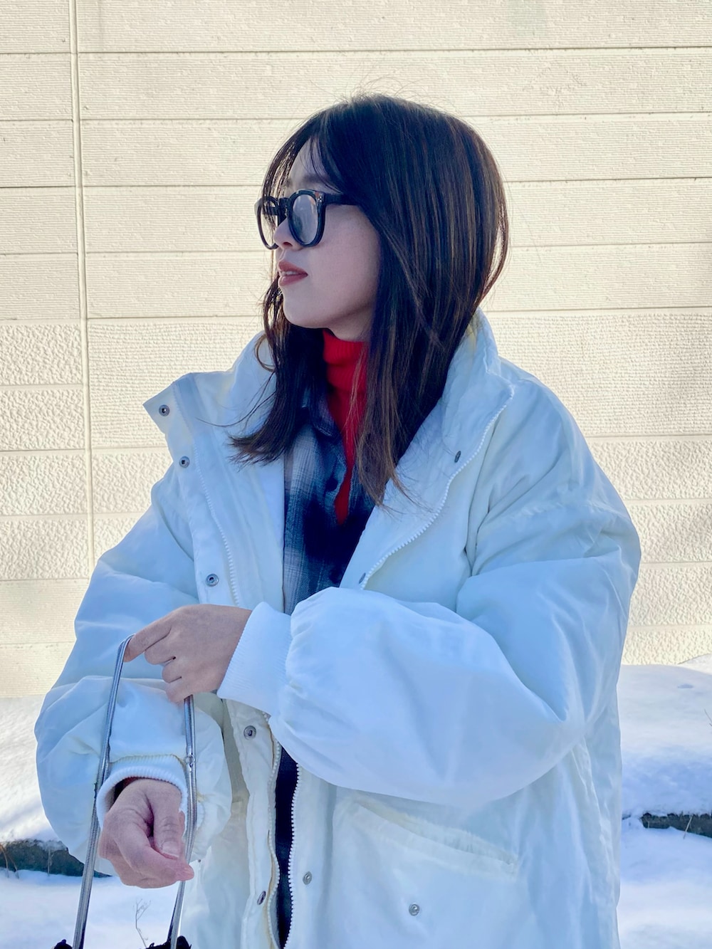 ホワイト系のダウンジャケット/コート、レッド系のニット/セーター、ブラック系のシャツ/ブラウスを着用したレディースの冬コーディネートの5枚目の写真