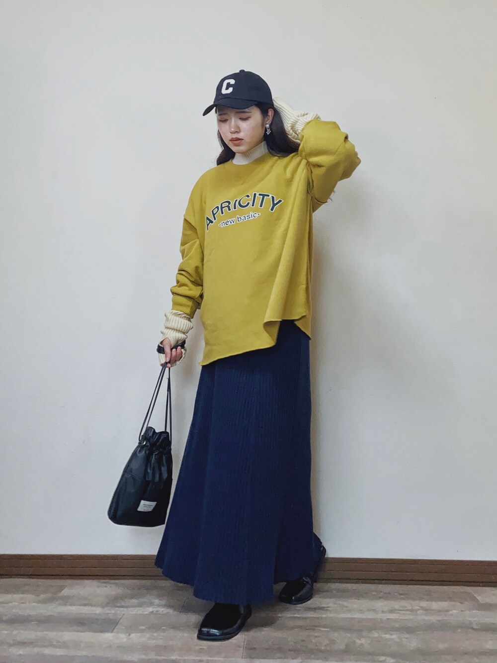 「冬のコーデ、スウェット、カレッジスウェット、カレッジロゴ、ニットスカート、ロングスカート、スクエアトゥ、キャップ、ハイネックニット、レイヤードスタイル、アームウォーマー、feepur、大人カジュアル、ショートブーツ、プチプラ」｜「feepur by sayaの【sayaコラボ】カレッジロゴスウェット（スウェット、イエロー系）」を使った、Miiさん（レディース・159cm）の冬コーディネートの2枚目の写真