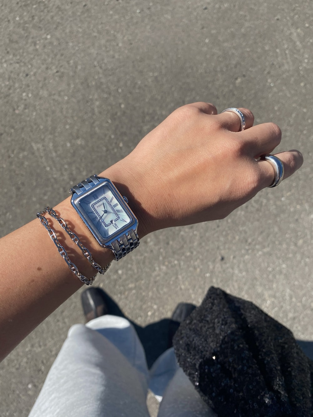 グレー系のスウェットパンツ、ブラック系のブーツ、シルバー系のアナログ腕時計を着用したレディースの秋コーディネートの3枚目の写真