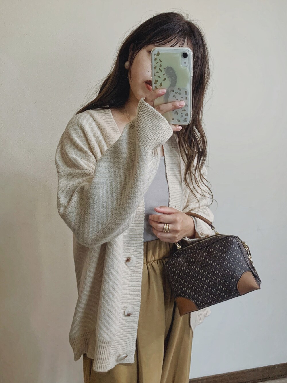 ベージュ系のカーディガン/ボレロ、ベージュ系のスウェットパンツ、ブラウン系のショルダーバッグを着用したレディースの秋コーディネートの3枚目の写真