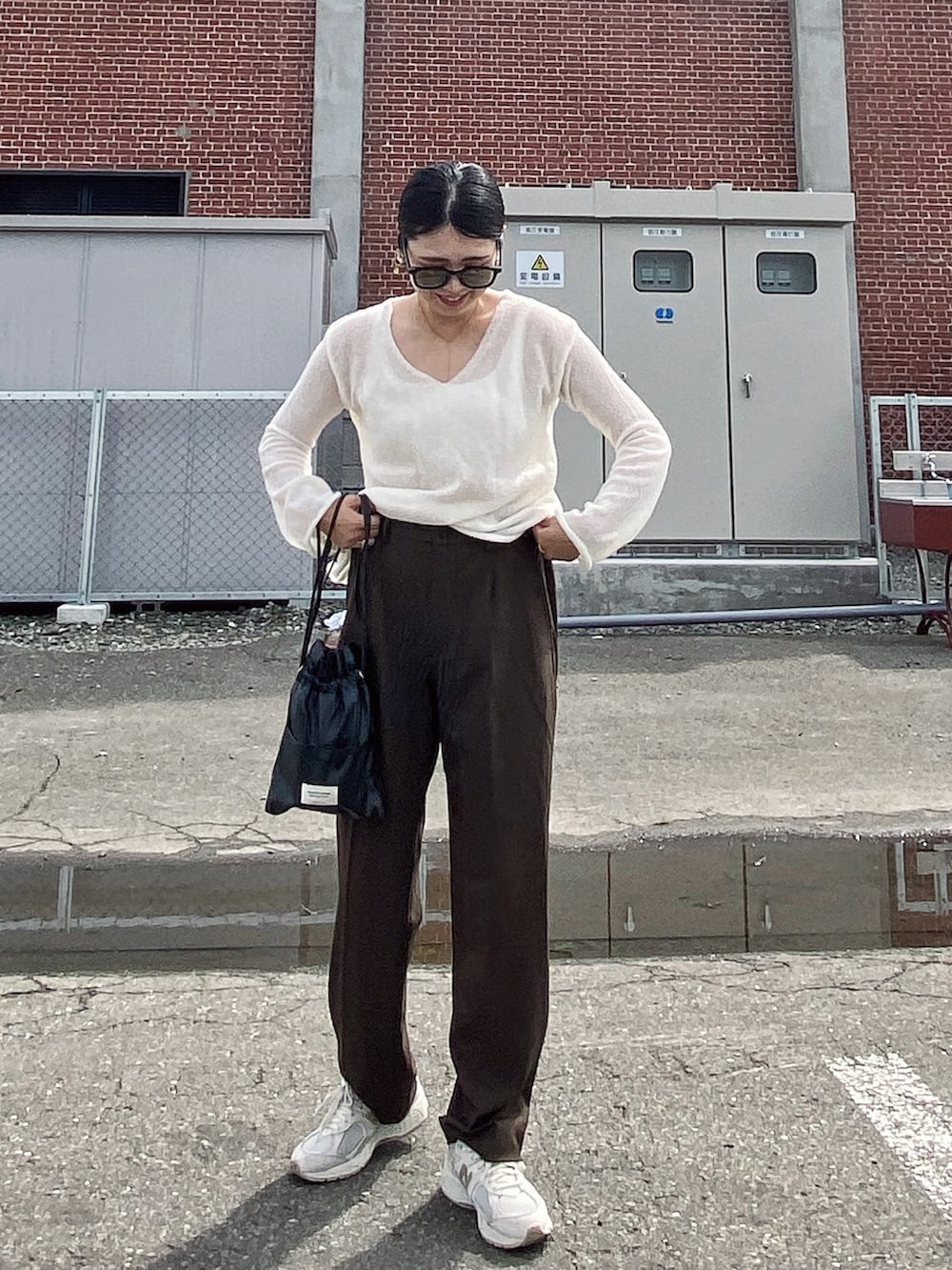 ホワイト系のその他トップス、ブラウン系のパンツ、ブラック系のショルダーバッグを着用したレディースの夏コーディネートの3枚目の写真