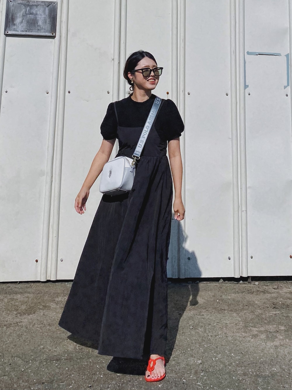 ブラック系のTシャツ/カットソー、ホワイト系のショルダーバッグ、ブラック系のワンピースを着用したレディースの夏コーディネートの2枚目の写真