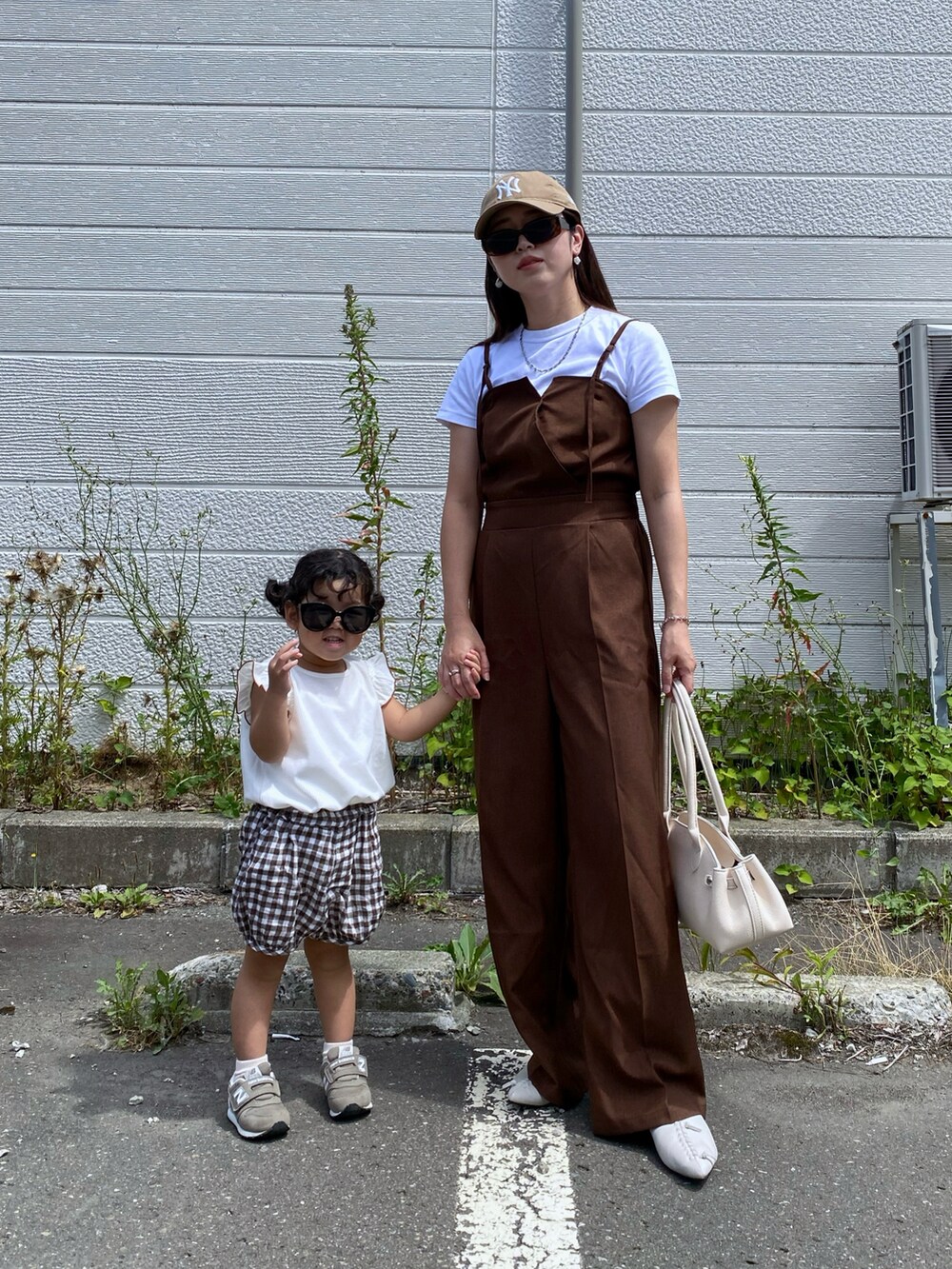 ブラック系のボストンバッグ、ベージュ系のキャップを着用したレディースの夏コーディネートの4枚目の写真