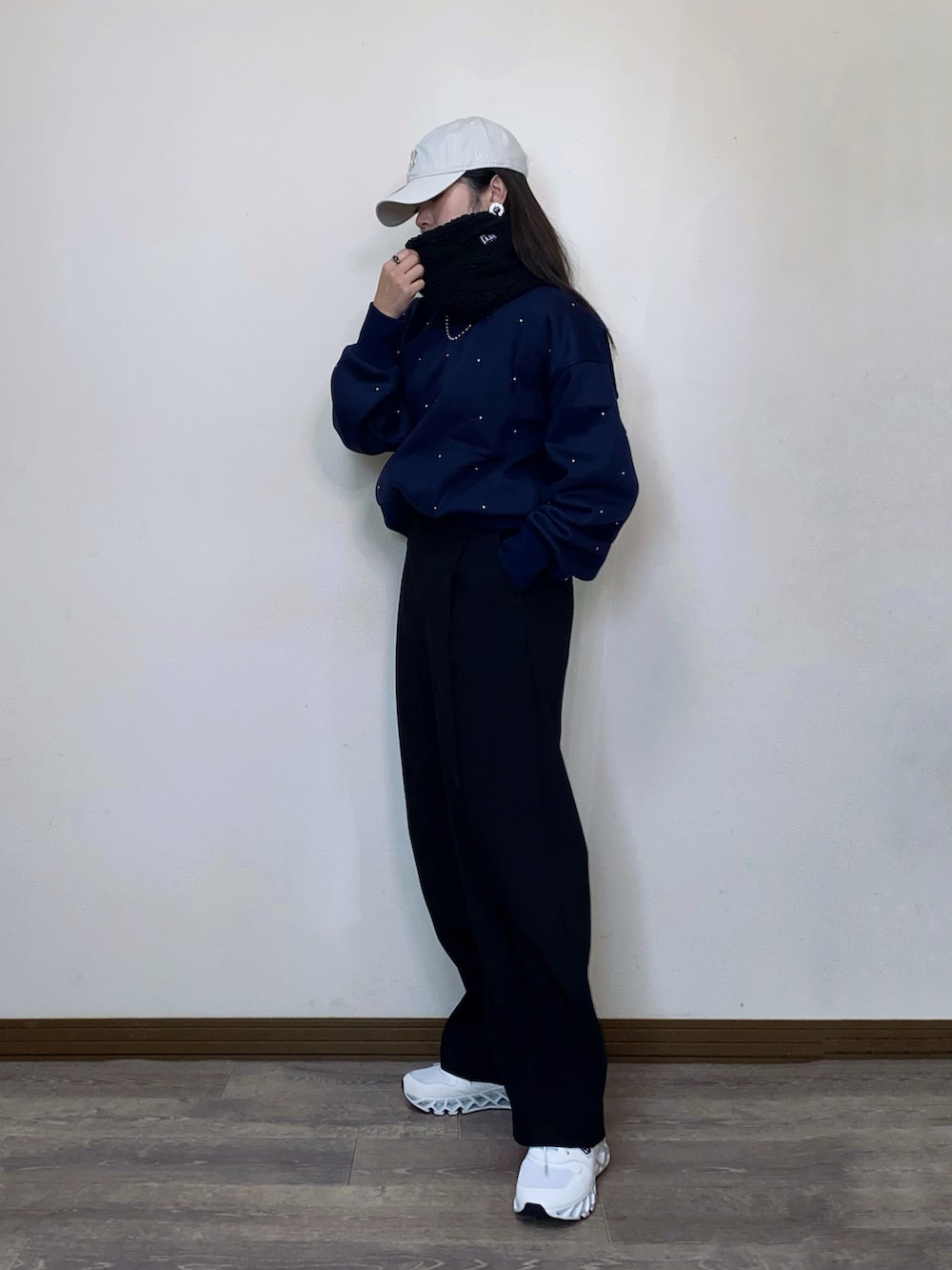 ブルー系のスウェット、ベージュ系のキャップ、ブラック系のネックウォーマー/スヌードを着用したレディースの冬コーディネートの4枚目の写真