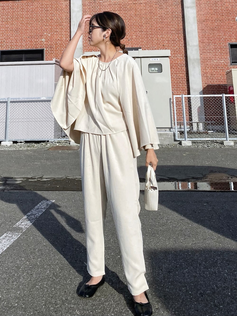 ホワイト系のショルダーバッグ、ブラック系のパンプス、シルバー系のリングを着用したレディースの秋コーディネートの2枚目の写真