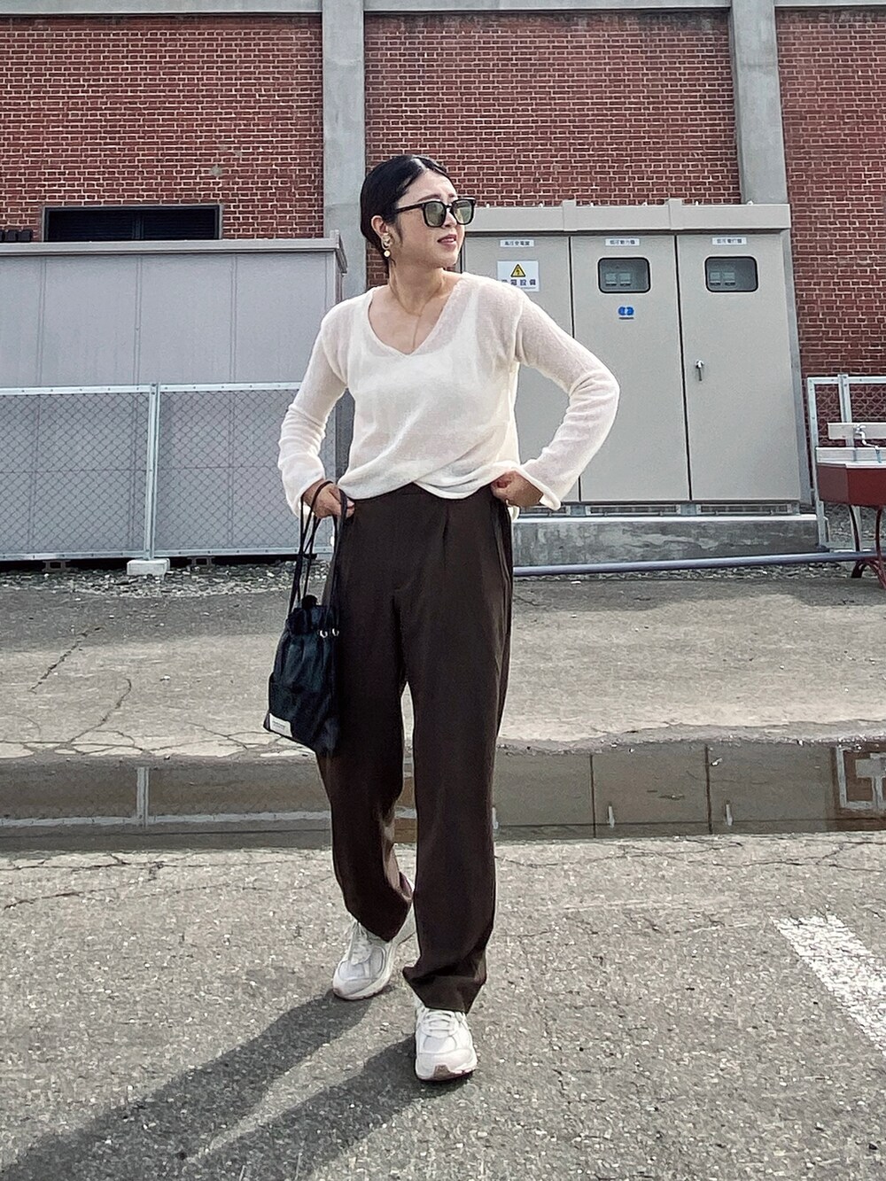 ホワイト系のその他トップス、ブラウン系のパンツ、ブラック系のショルダーバッグを着用したレディースの夏コーディネートの2枚目の写真