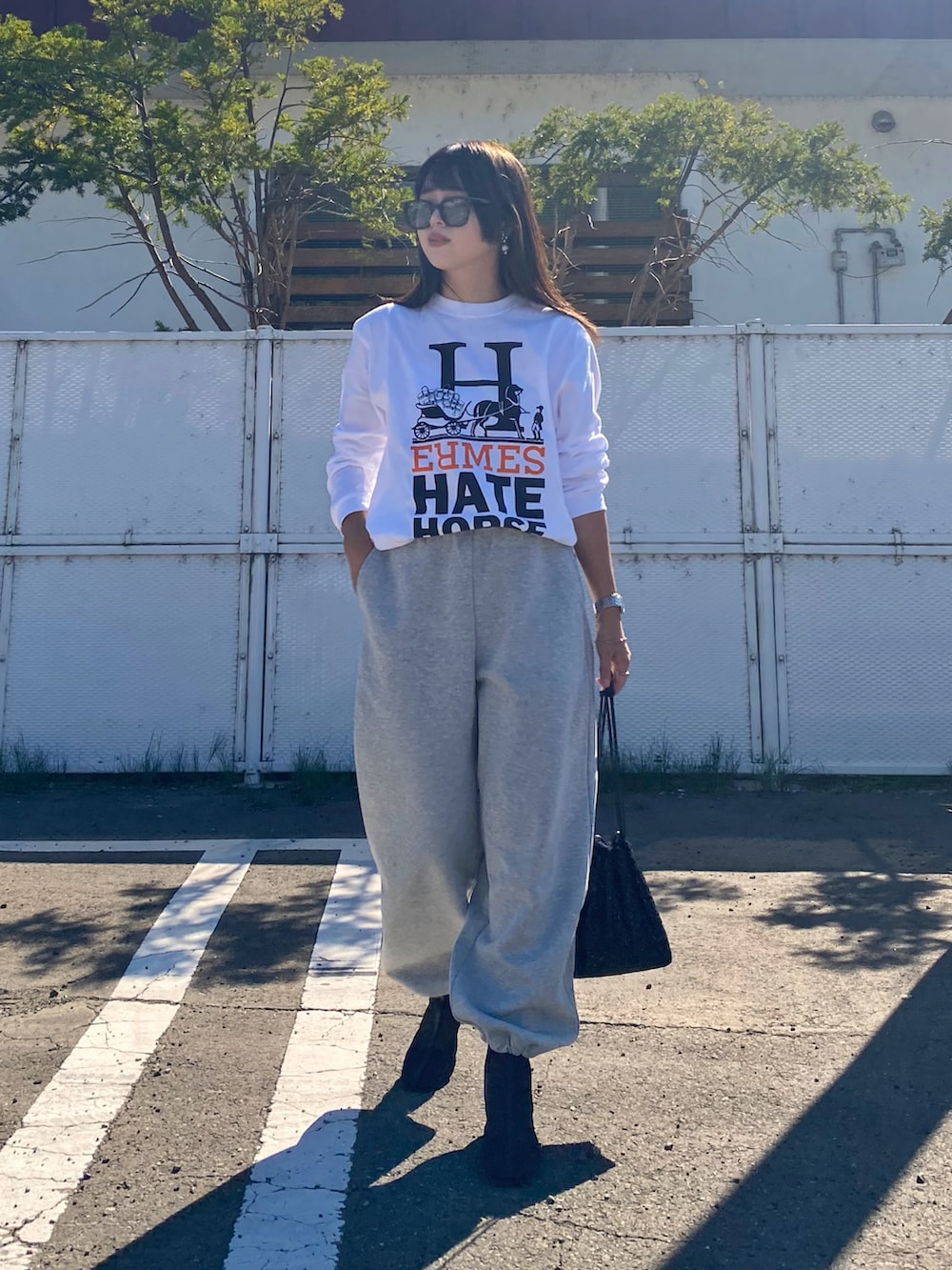 グレー系のスウェットパンツ、ブラック系のブーツ、シルバー系のアナログ腕時計を着用したレディースの秋コーディネートの2枚目の写真