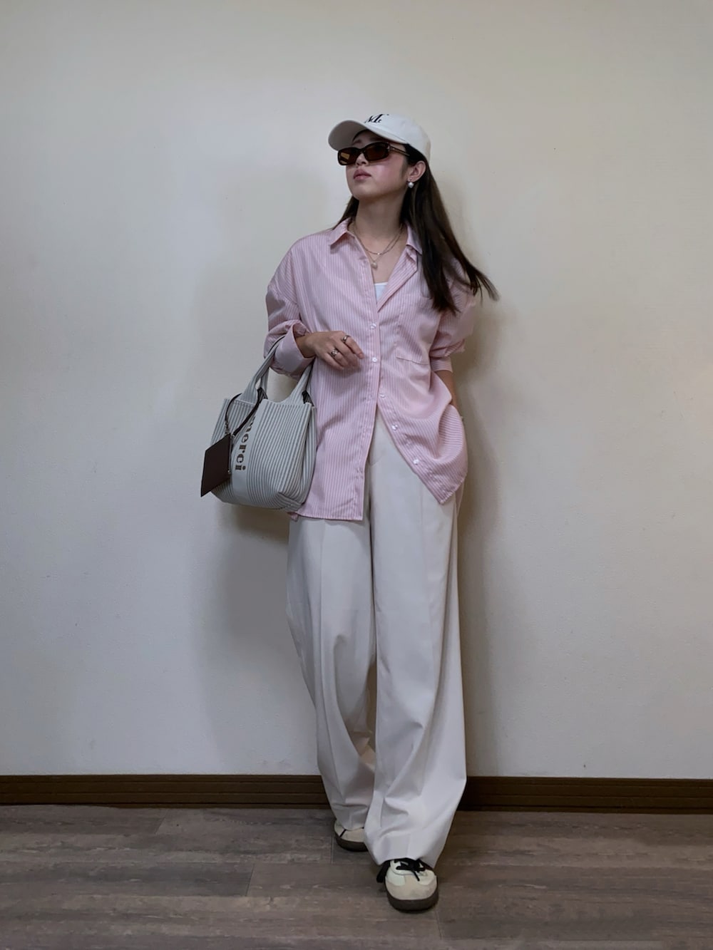 「シャツスタイル、ストライプシャツ、ピンク、パステルカラー、白パンツ、タックワイドパンツ、スニーカー、キャップ、オーバーサイズ、春コーデ、UNIQLO、adidas、サングラス、大人カジュアル、ラフ」｜「recaの先染めストライプ＆無地BIGシャツ（シャツ/ブラウス、ピンク系）」を使った、Miiさん（レディース・159cm）の冬コーディネートの2枚目の写真