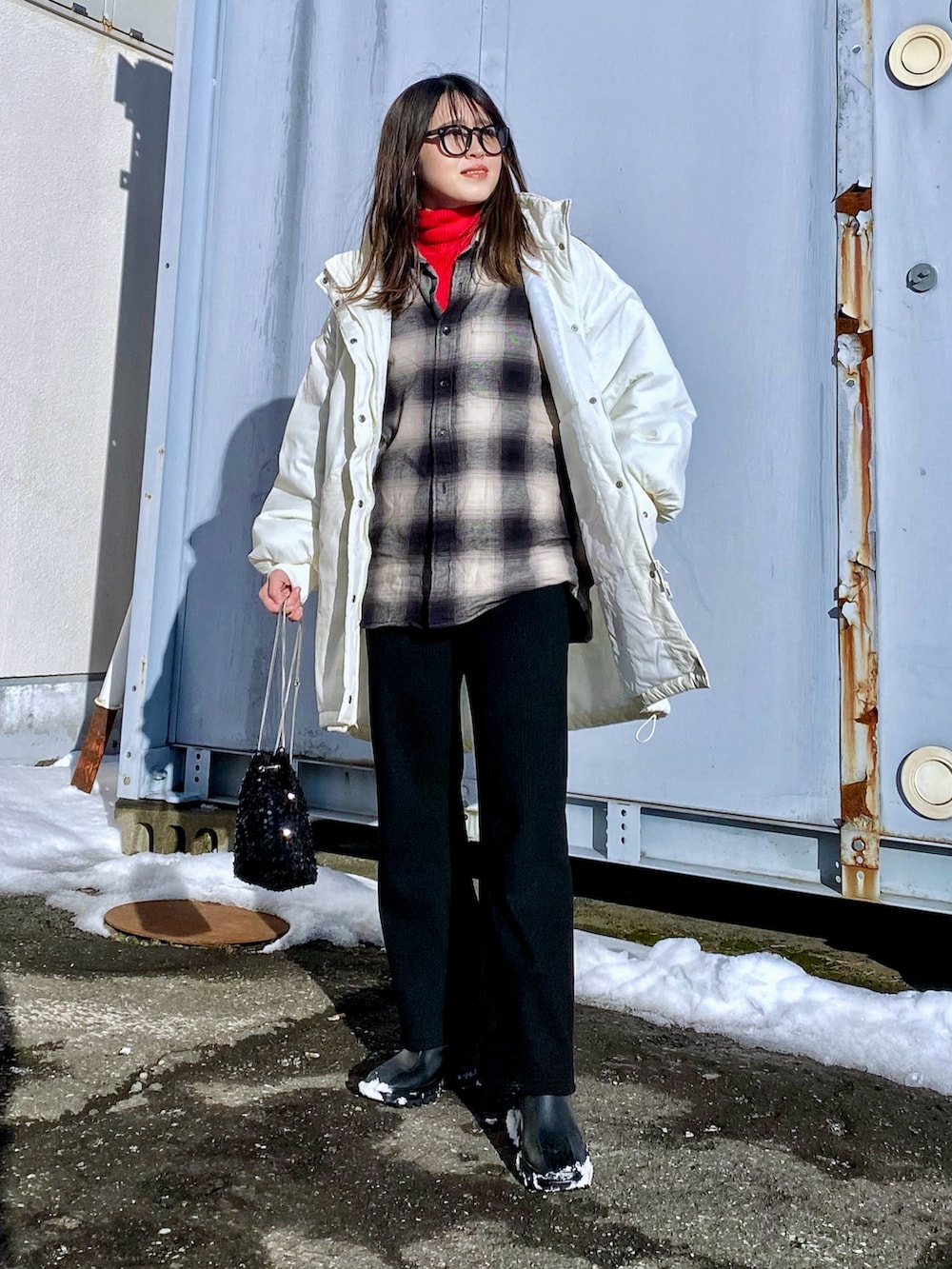 ホワイト系のダウンジャケット/コート、レッド系のニット/セーター、ブラック系のシャツ/ブラウスを着用したレディースの冬コーディネートの4枚目の写真