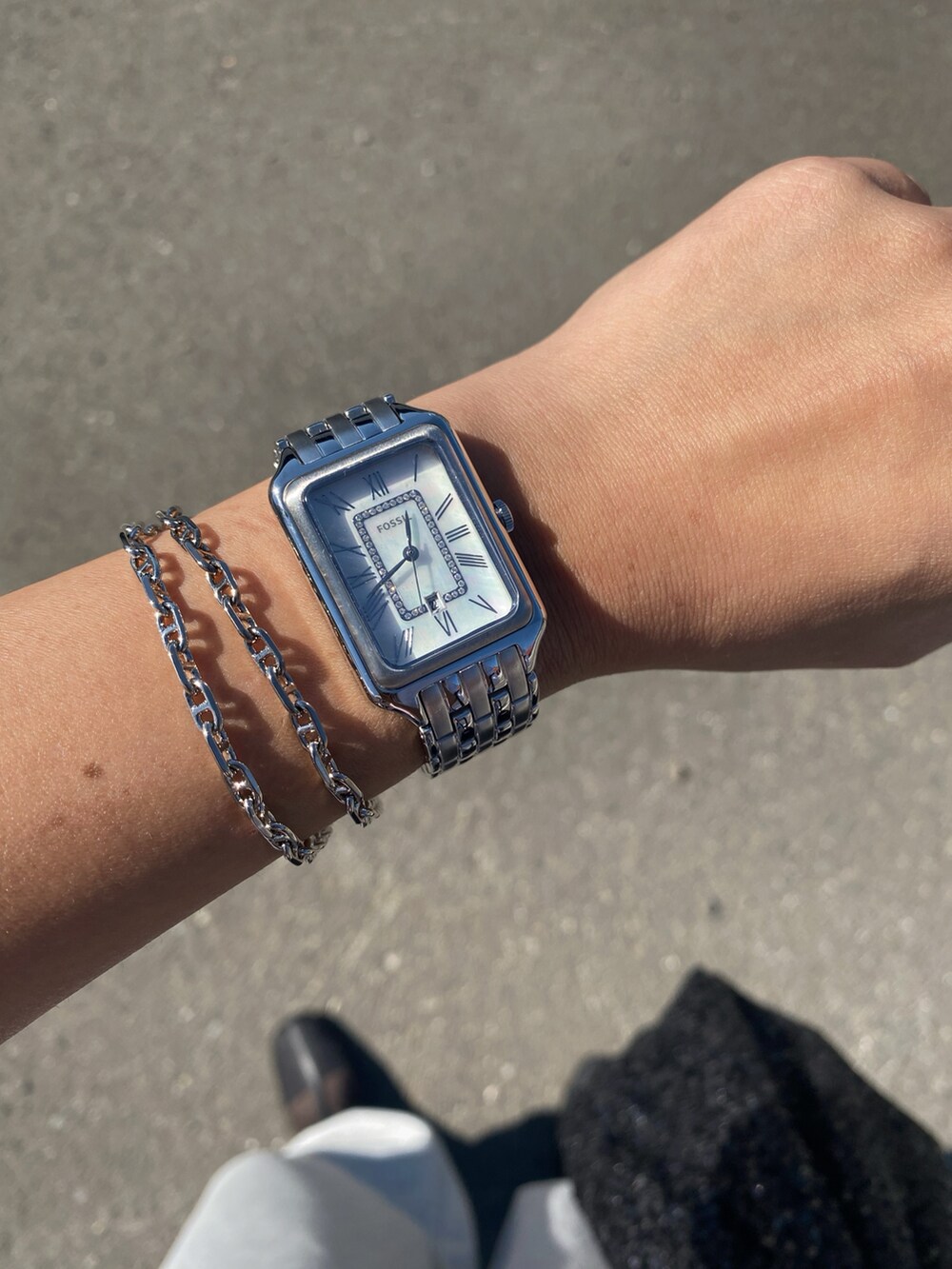 グレー系のスウェットパンツ、ブラック系のブーツ、シルバー系のアナログ腕時計を着用したレディースの秋コーディネートの4枚目の写真