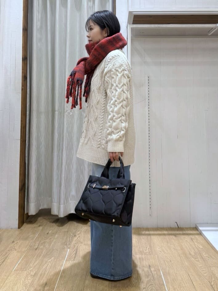ホワイト系のニット/セーター、ブルー系のデニムパンツ、ブラック系のトートバッグを着用したレディースの冬コーディネートの2枚目の写真