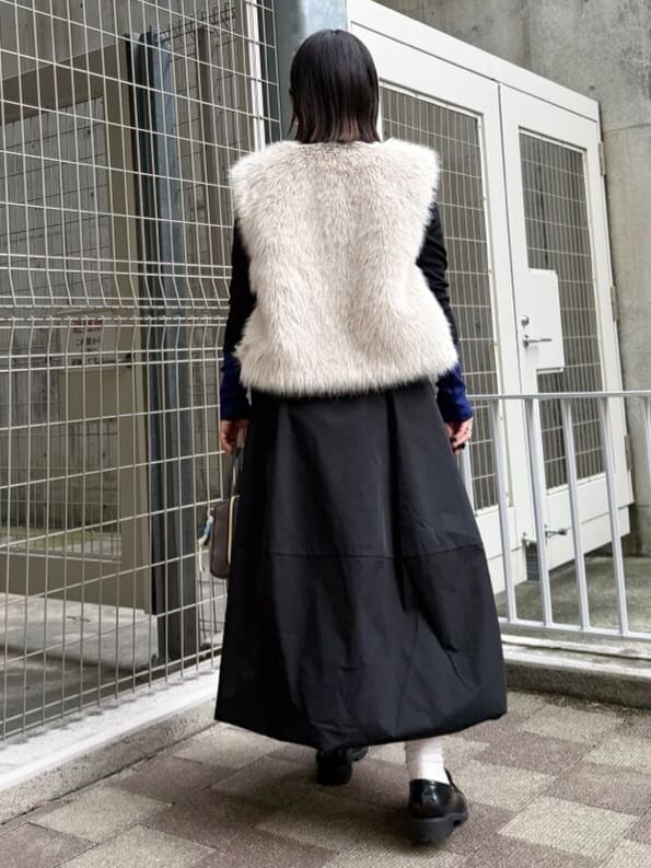 ベージュ系のベスト、ブラック系のTシャツ/カットソー、ブラック系のスカートを着用したレディースの秋コーディネートの5枚目の写真