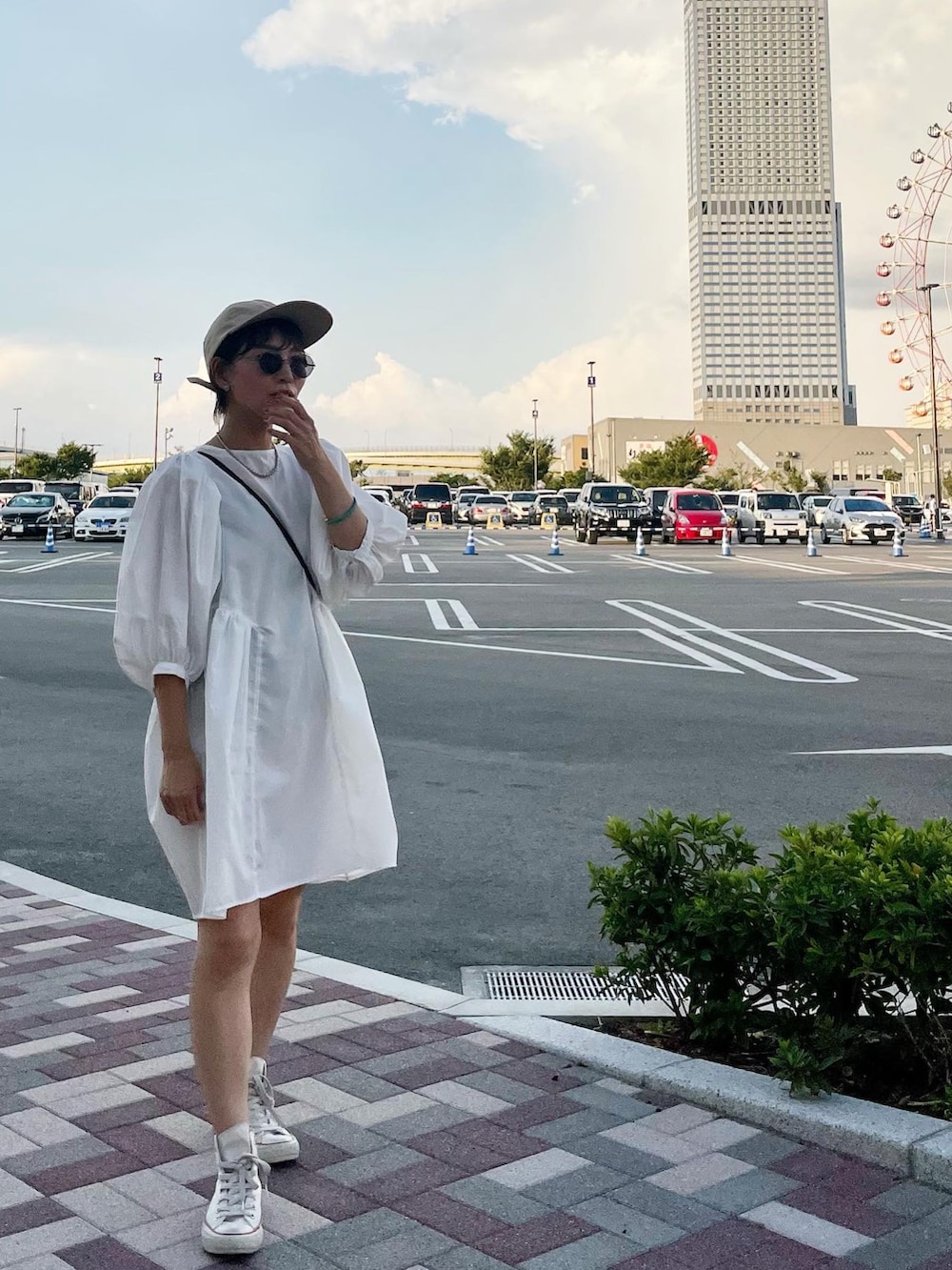 ホワイト系のスニーカーを着用したレディースの夏コーディネートの2枚目の写真