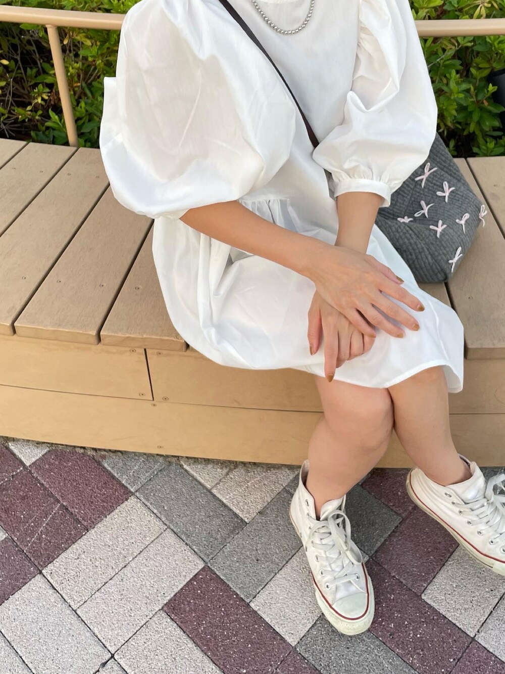 ホワイト系のスニーカーを着用したレディースの夏コーディネートの3枚目の写真