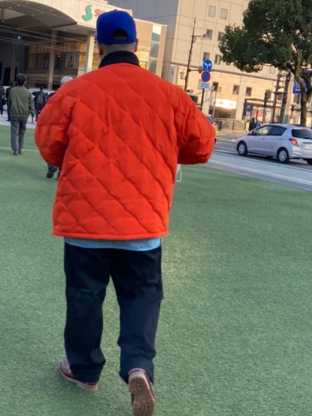 オレンジ系のブルゾン、ブルー系のシャツ/ブラウス、ブラック系のチノパンツを着用したメンズの冬コーディネートの2枚目の写真