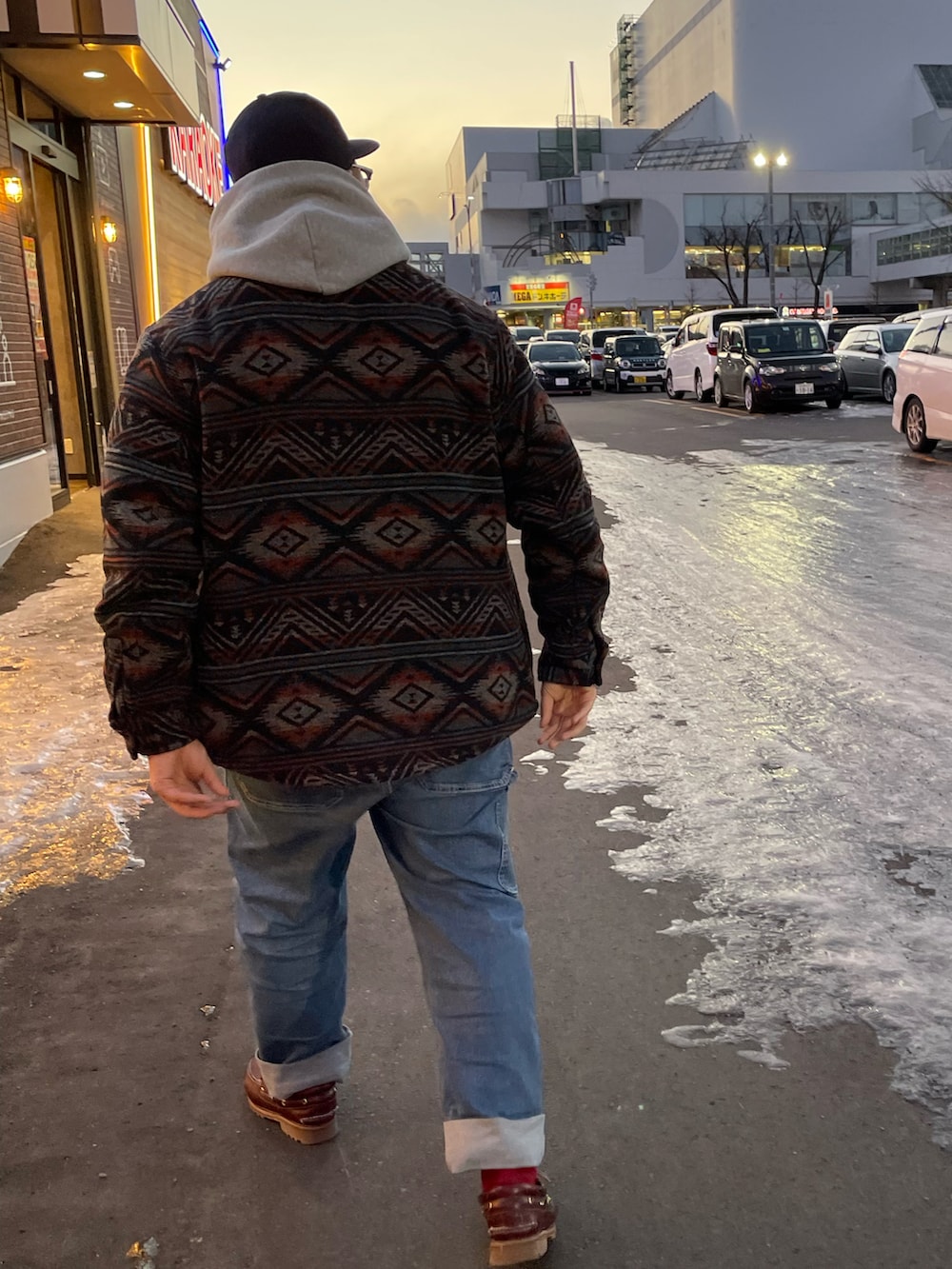 ブラウン系のジャケット/アウター、グレー系のパーカー、ブルー系のデニムパンツを着用したメンズの春コーディネートの2枚目の写真