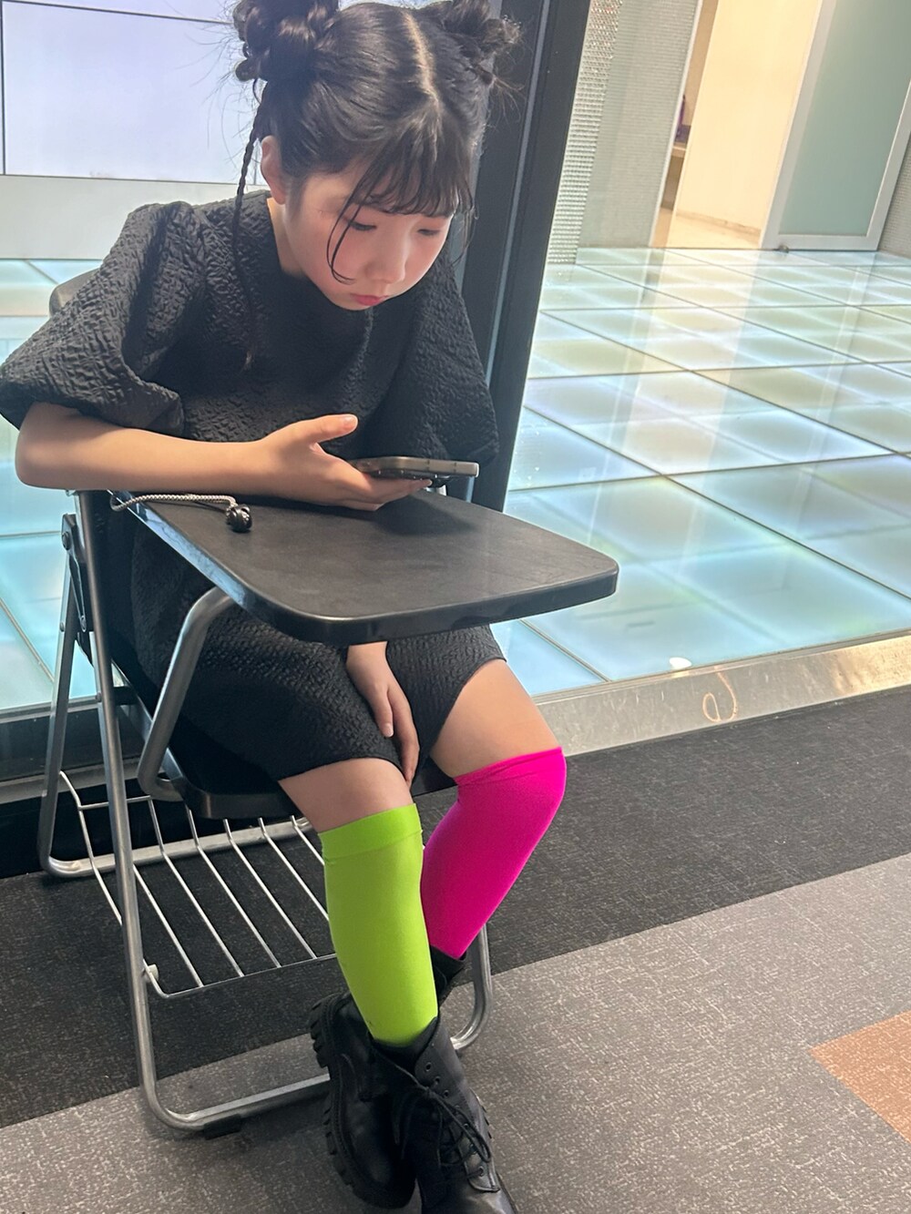 ブラック系のチュニック、ブラック系のブーツを着用したキッズの春コーディネートの2枚目の写真