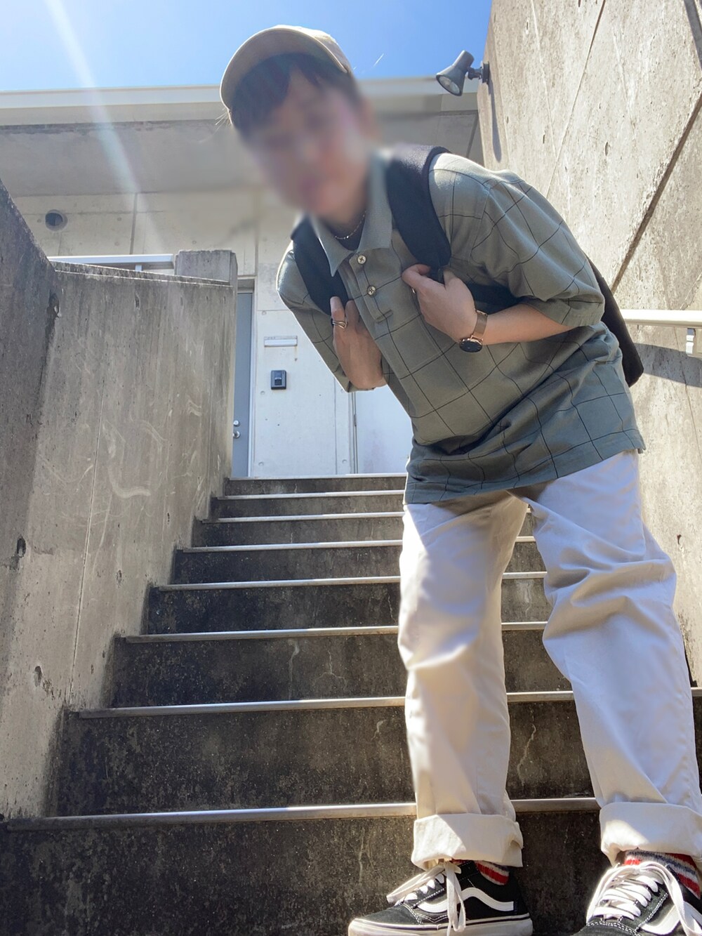 ブラック系のバックパック/リュック、グリーン系のポロシャツ、ブラック系のスニーカーを着用したレディースの夏コーディネートの3枚目の写真