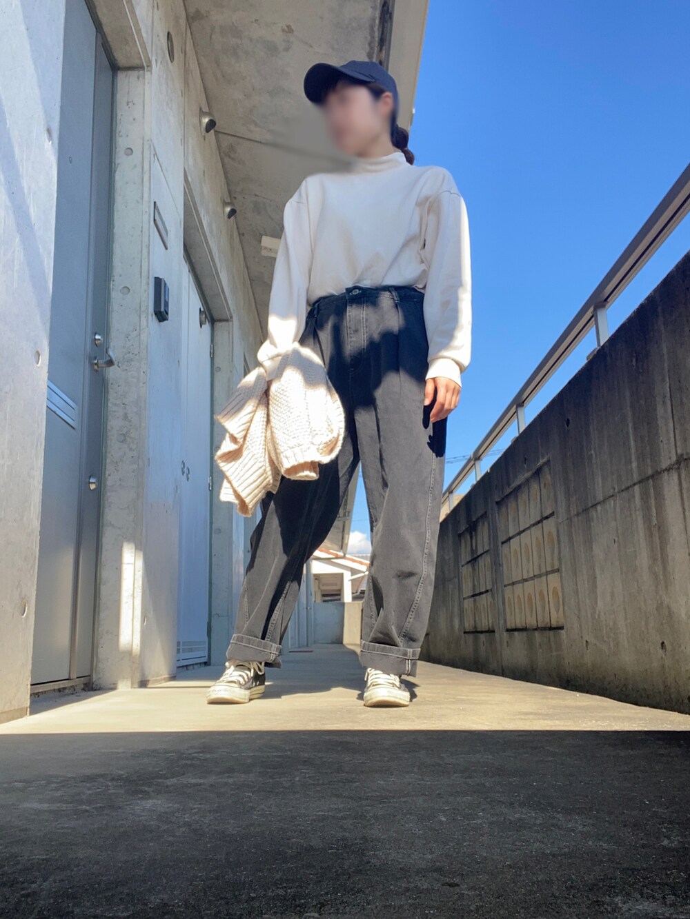 ブラック系のスニーカー、ブラック系のデニムパンツ、ホワイト系のTシャツ/カットソーを着用したレディースの秋コーディネートの3枚目の写真