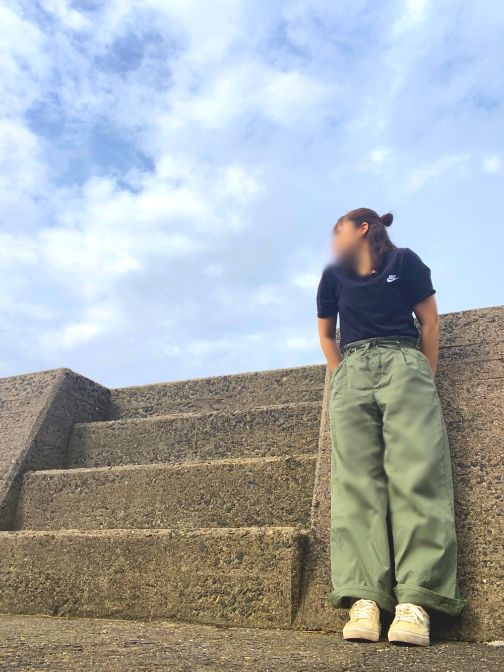 グリーン系のパンツ、ブラック系のTシャツ/カットソー、ベージュ系のスニーカーを着用したレディースの夏コーディネートの4枚目の写真