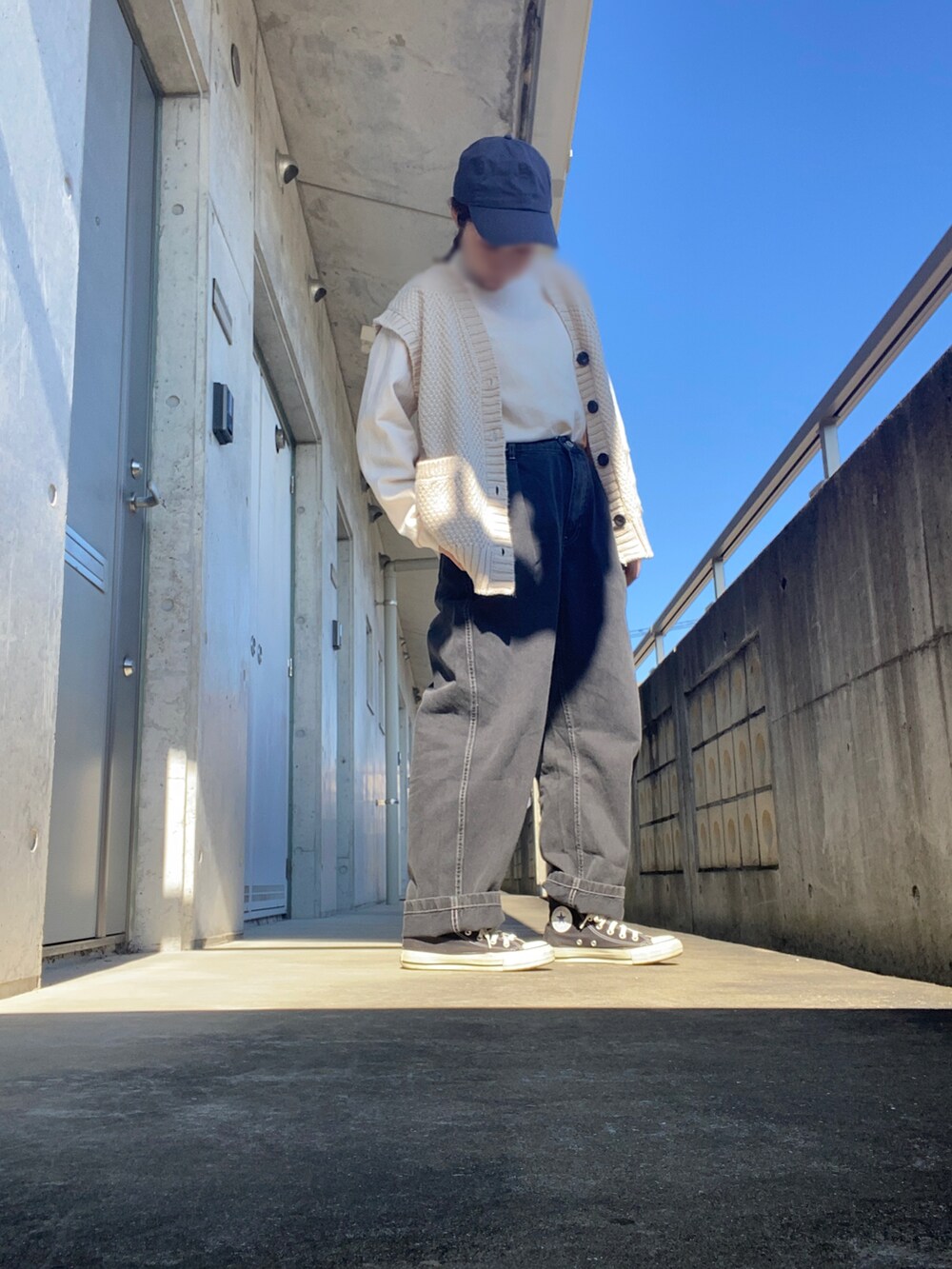 ブラック系のスニーカー、ブラック系のデニムパンツ、ホワイト系のTシャツ/カットソーを着用したレディースの秋コーディネートの2枚目の写真