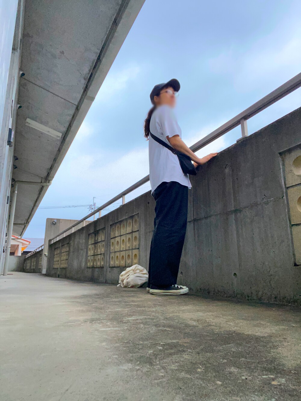 ブラック系のスラックス、ホワイト系のTシャツ/カットソー、ブラック系のスニーカーを着用したレディースの夏コーディネートの3枚目の写真