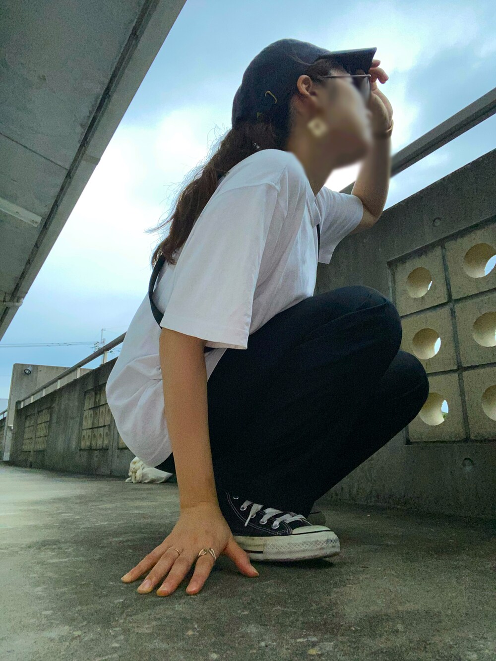 ブラック系のスラックス、ホワイト系のTシャツ/カットソー、ブラック系のスニーカーを着用したレディースの夏コーディネートの2枚目の写真