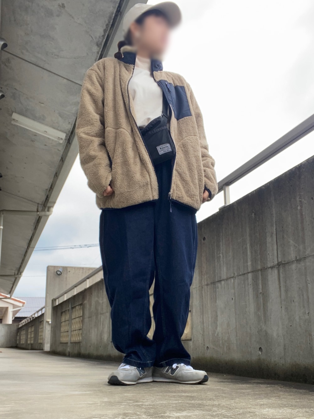 ベージュ系のジャケット/アウター、ブルー系のデニムパンツ、グレー系のスニーカーを着用したレディースの冬コーディネートの2枚目の写真