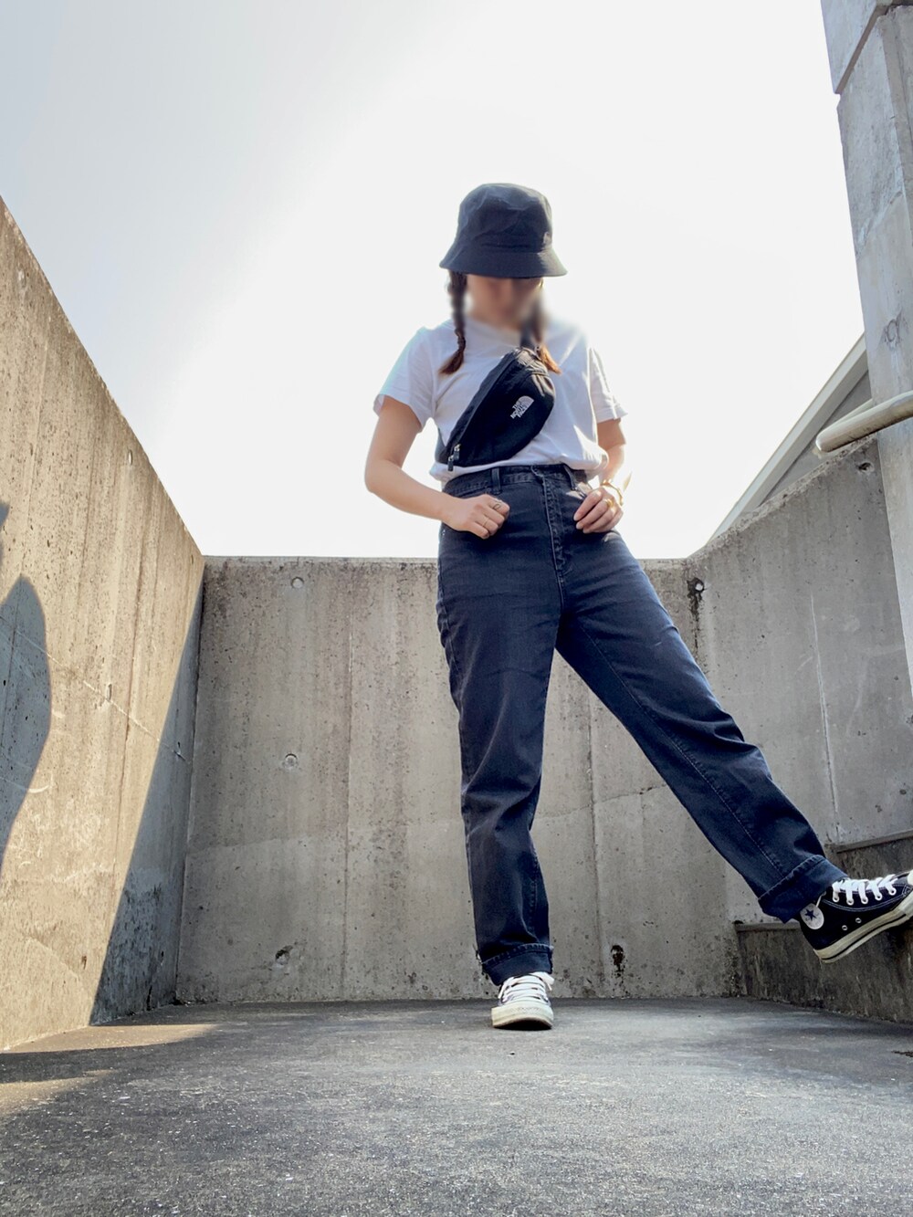 ブラック系のデニムパンツ、ブラック系のボディバッグ/ウエストポーチ、ホワイト系のTシャツ/カットソーを着用したレディースの秋コーディネートの2枚目の写真