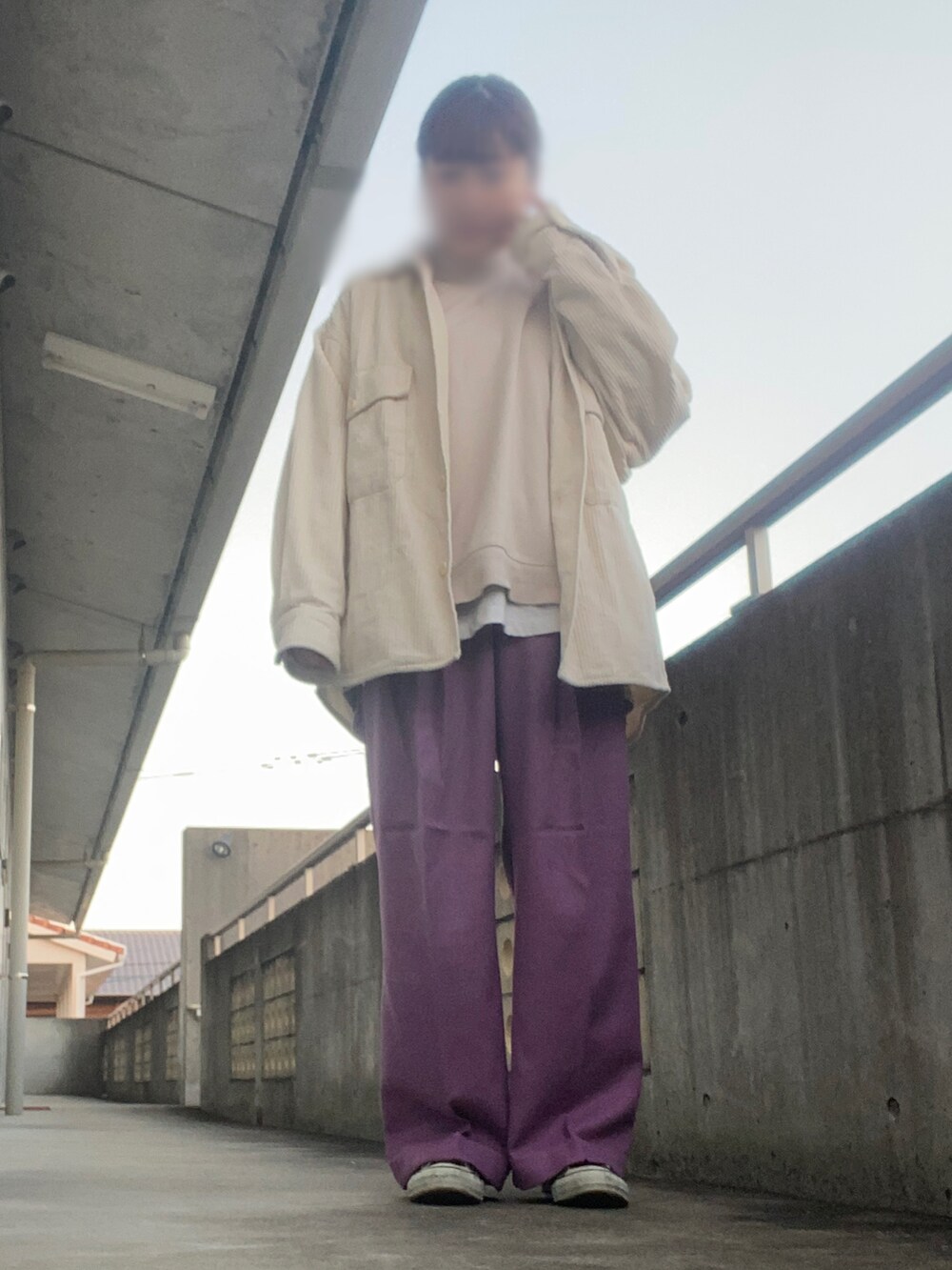 パープル系のパンツ、ベージュ系のトップス、グリーン系のベストを着用したレディースの冬コーディネートの2枚目の写真