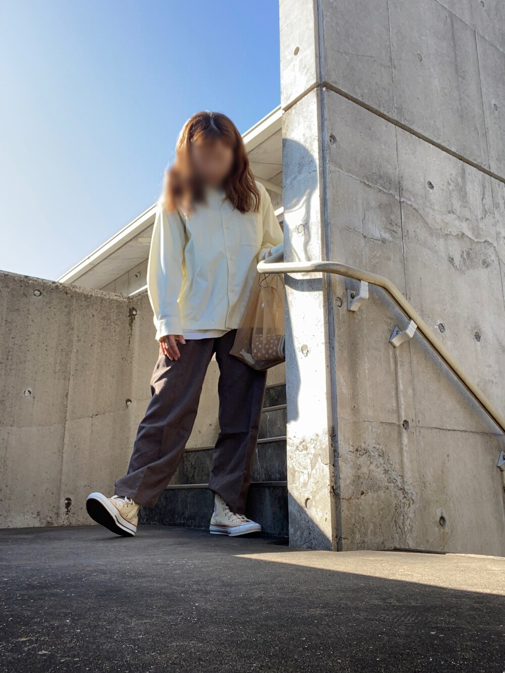 イエロー系のシャツ/ブラウス、ブラウン系のパンツ、ブラウン系のバッグを着用したレディースの秋コーディネートの2枚目の写真