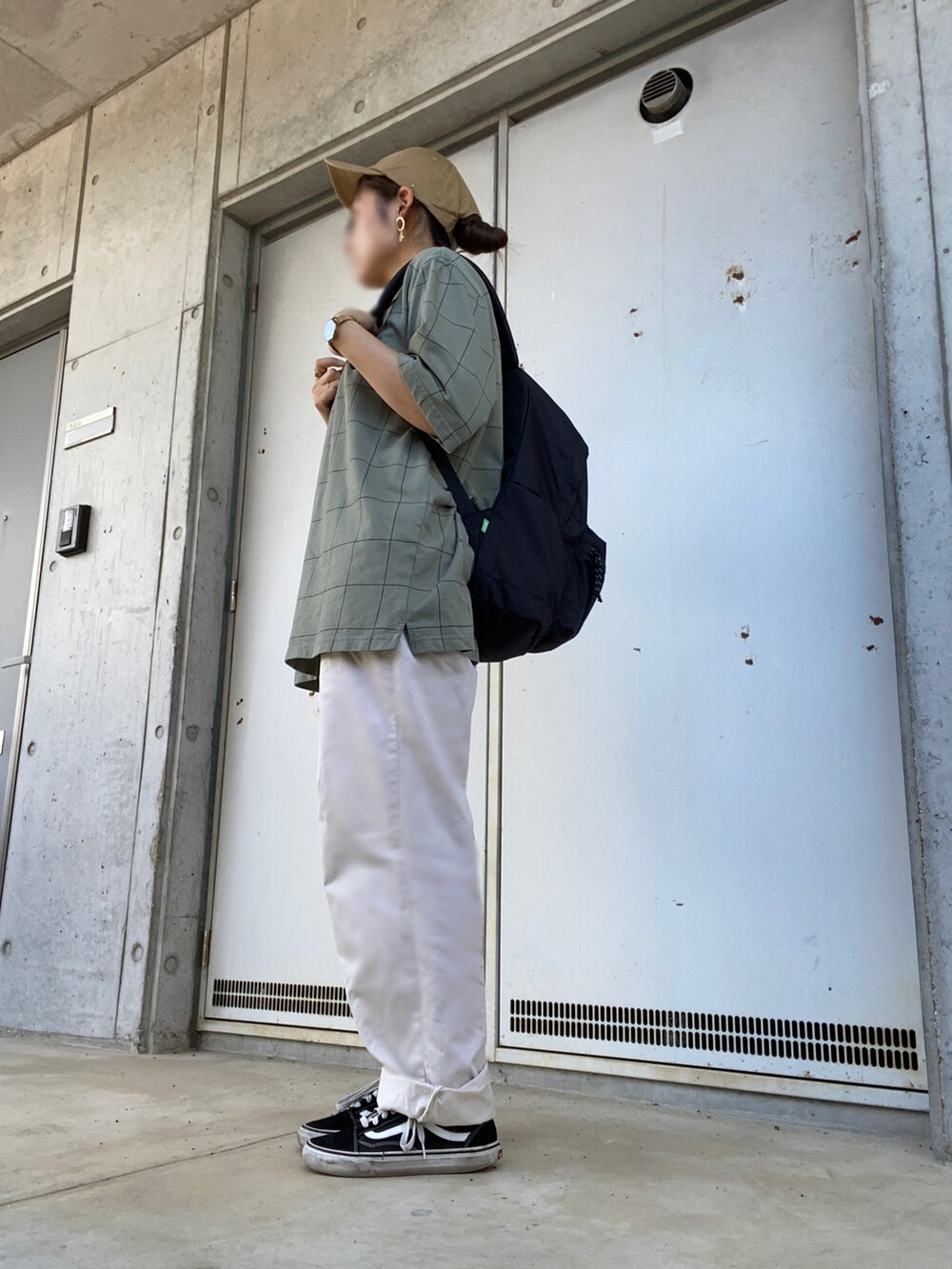 ブラック系のバックパック/リュック、グリーン系のポロシャツ、ブラック系のスニーカーを着用したレディースの夏コーディネートの2枚目の写真