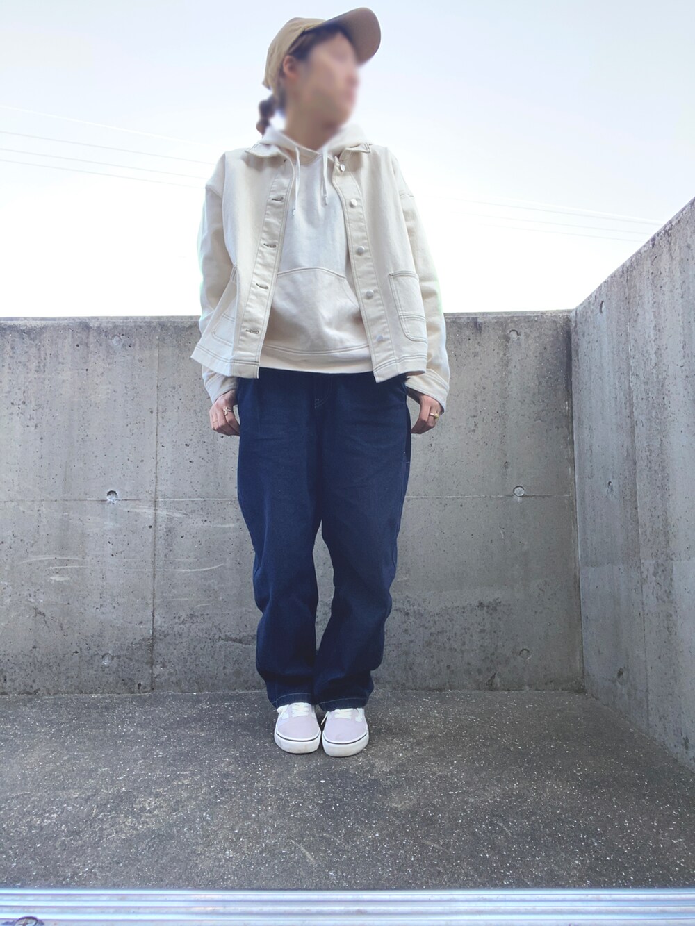 ブルー系のデニムパンツ、ホワイト系のパーカー、パープル系のスニーカーを着用したレディースの秋コーディネートの3枚目の写真