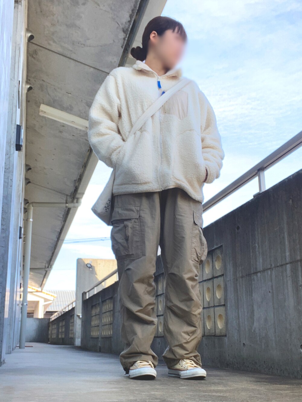 ベージュ系のバッグ、ホワイト系のスニーカー、ベージュ系のカーゴパンツを着用したレディースの冬コーディネートの2枚目の写真