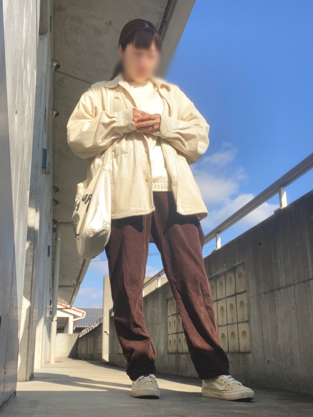 ブラウン系のパンツ、ベージュ系のスニーカー、ベージュ系のトップスを着用したレディースの冬コーディネートの2枚目の写真