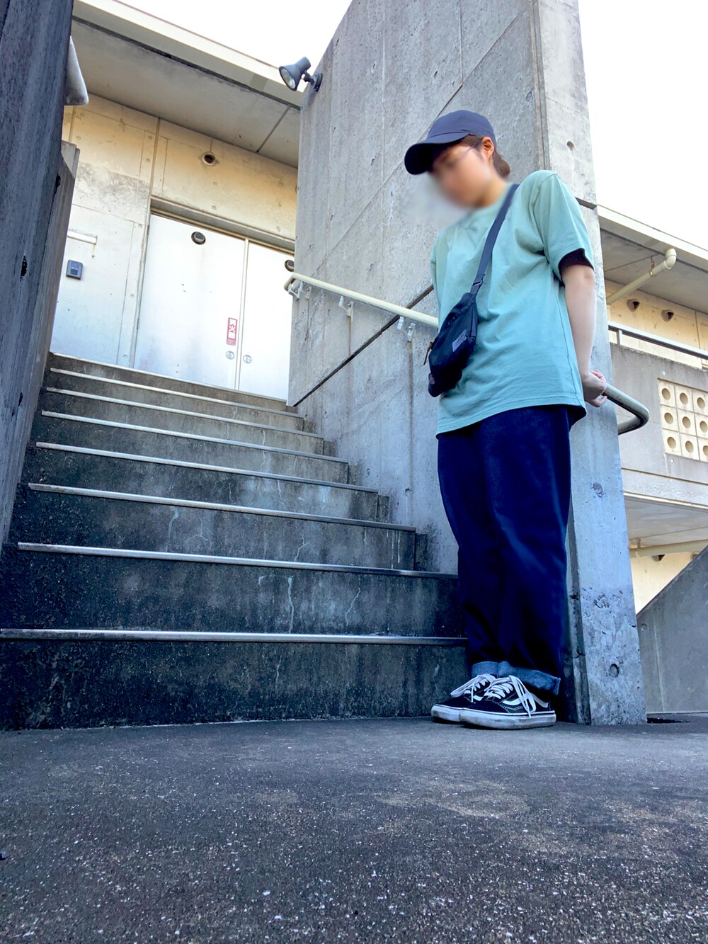 ブルー系のパンツ、グリーン系のTシャツ/カットソー、ブラック系のスニーカーを着用したレディースの夏コーディネートの3枚目の写真