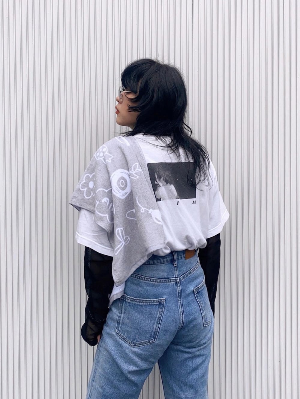 ブルー系のデニムパンツ、ブラック系のスニーカー、ホワイト系のデニムジャケットを着用したレディースの春コーディネートの4枚目の写真