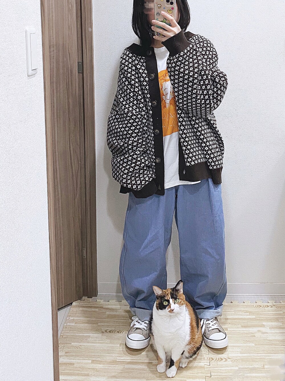 ブラウン系のカーディガン/ボレロ、ホワイト系のTシャツ/カットソー、ブルー系のデニムパンツを着用したレディースの春コーディネートの2枚目の写真