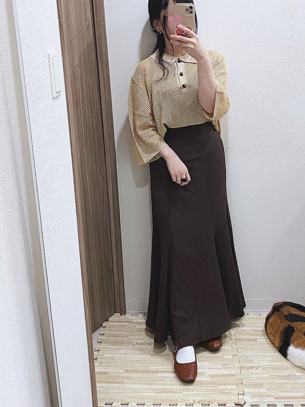 イエロー系のニット/セーター、ブラウン系のキャミソール、ブラウン系のスカートを着用したレディースの夏コーディネートの2枚目の写真